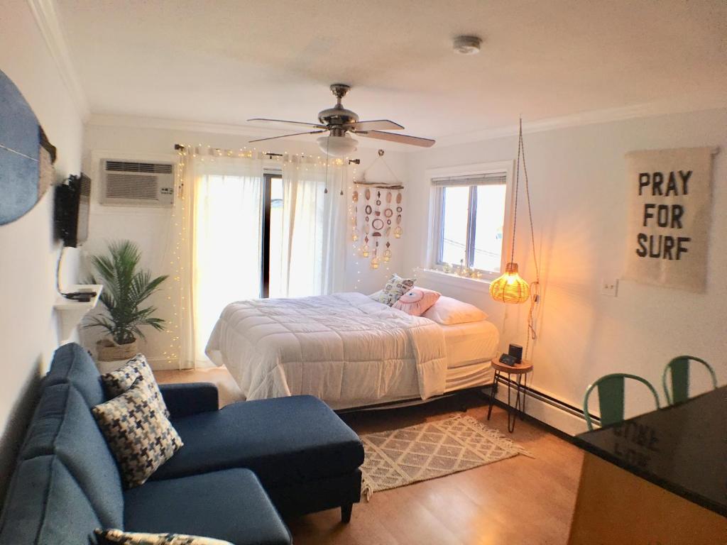 een slaapkamer met een bed en een blauwe bank bij Jonathan's Ocean Front Studio Suites Hampton Beach! in Hampton