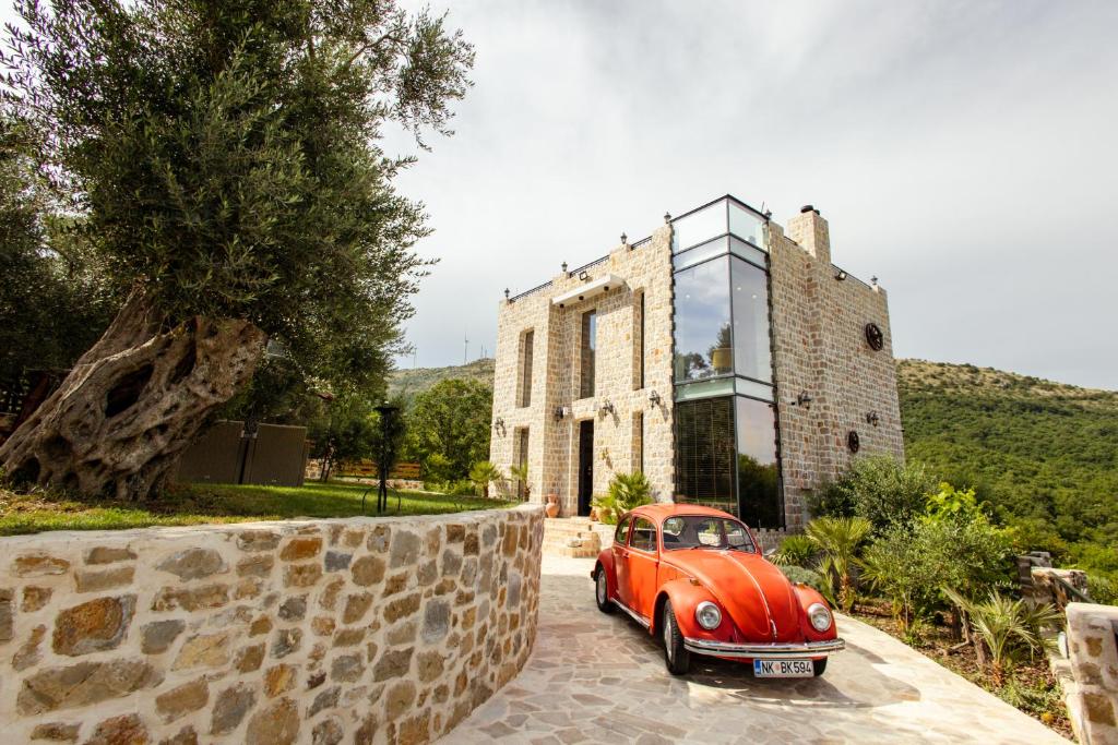 an orange car parked in front of a building at COUNTRYSIDE VILLA in Ulcinj