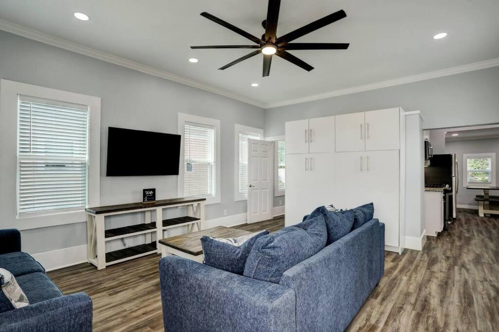 a living room with two blue couches and a ceiling fan at Renovated Beach Bungalow! in Galveston