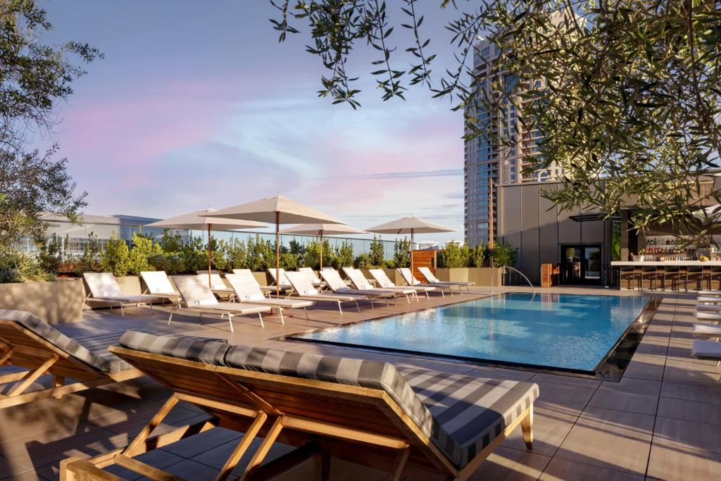 a swimming pool with lounge chairs and a building at Fairmont Century Plaza Los Angeles in Los Angeles