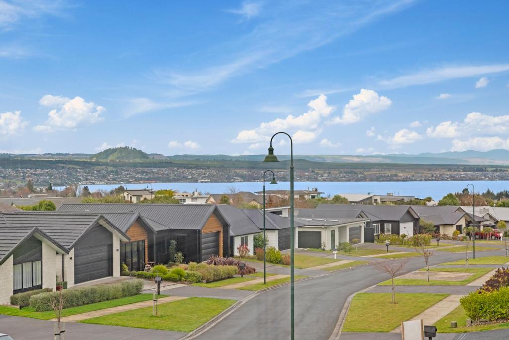 une rangée de maisons dans un quartier résidentiel avec un lac dans l'établissement Sanctuary on the Grove, à Taupo