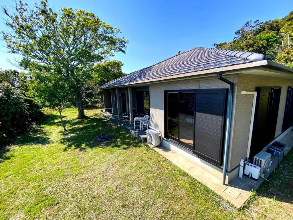 a house with a porch with chairs and a yard at Nonoya - Vacation STAY 78469v in Goto