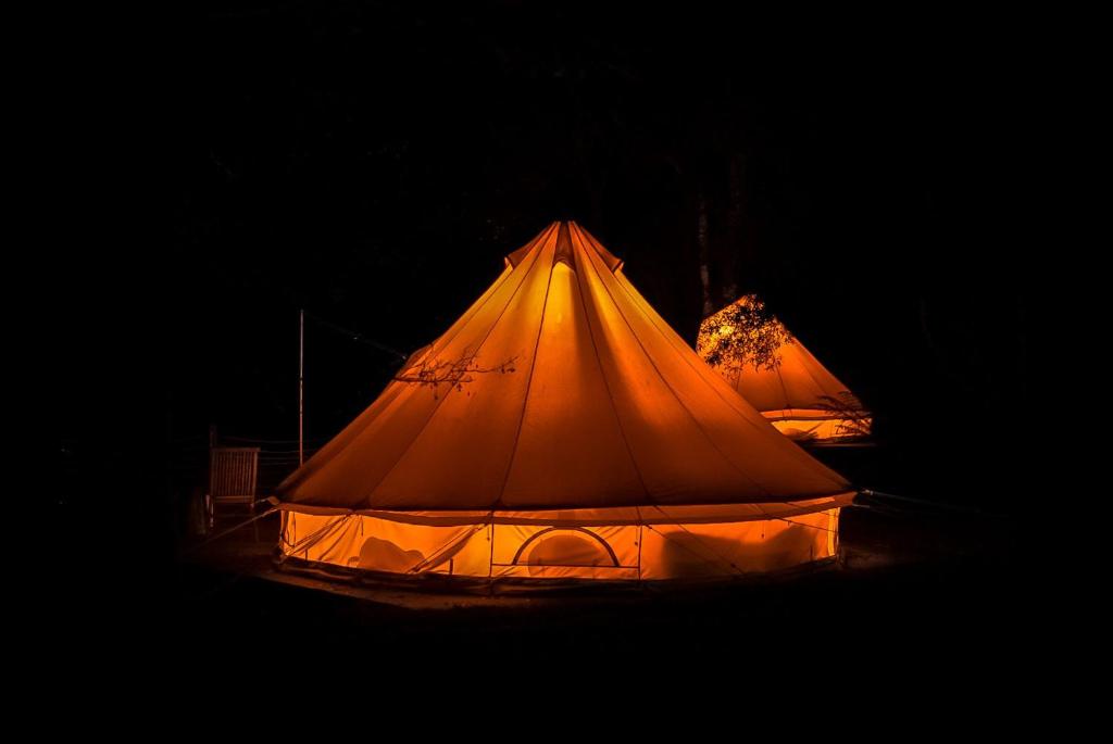 a tent is lit up in the dark at Garden Beds Glamping in Blackwood