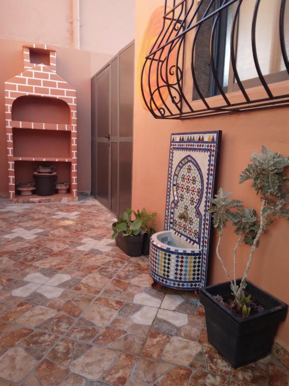 Dream House Sidi Ifni في سيدي إفني: غرفة بها كرسي وبعض النباتات الفخارية