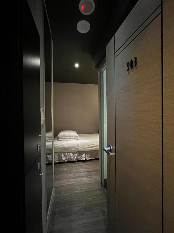 a room with a bed and a door leading to a bedroom at Main Inn Taipei in Taipei