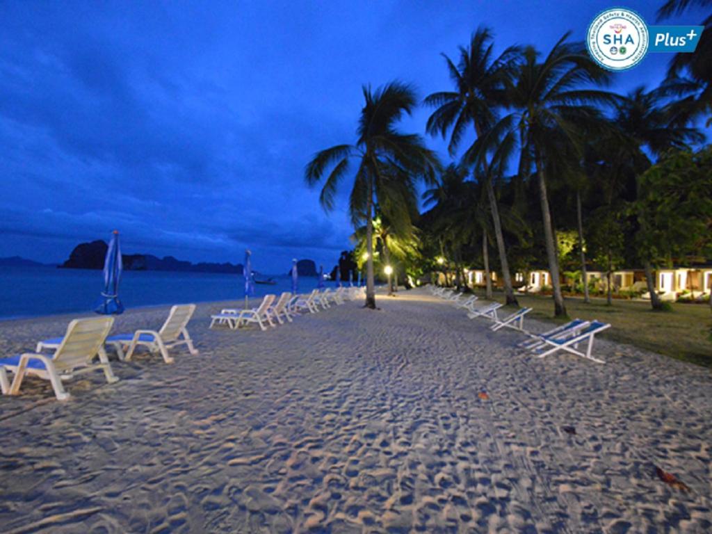 a row of chairs on a beach at night at Koh Hai Fantasy Resort & Spa in Ko Ngai