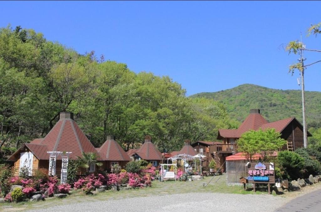 a group of houses with a mountain in the background at Finland Village Pension in Geoje