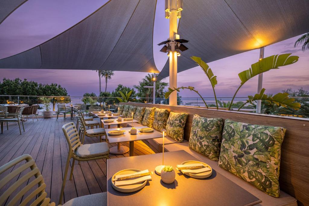a restaurant with tables and chairs on a deck at Crowne Plaza Limassol by IHG in Limassol