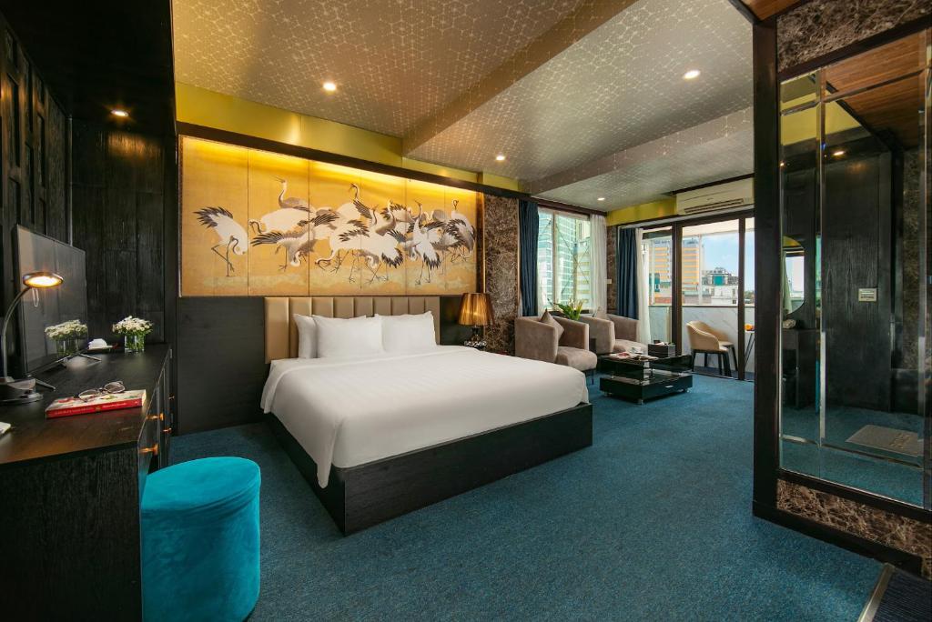 una camera d'albergo con letto e soggiorno di Ja Cosmo Hotel and Spa a Hanoi