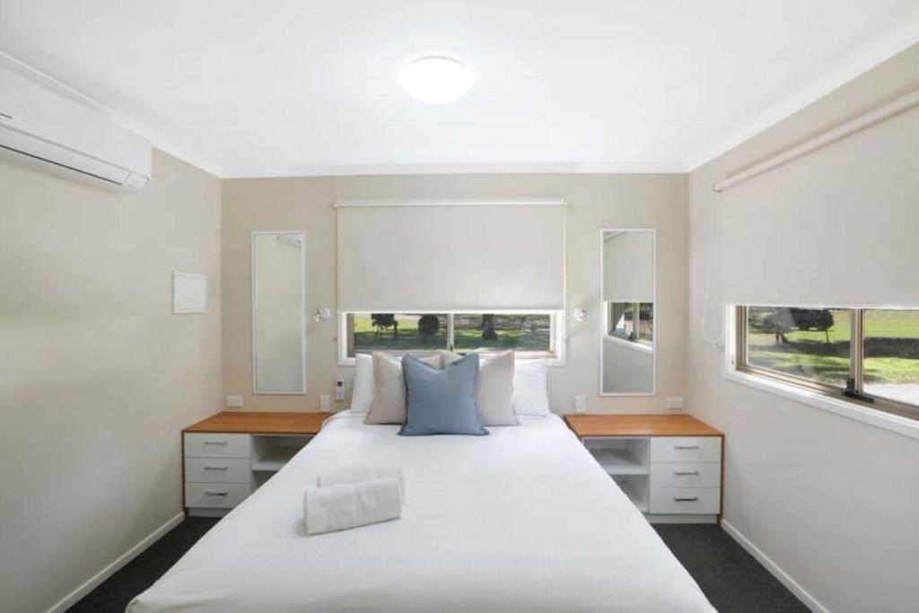 1 dormitorio con 1 cama blanca grande y 2 ventanas en Reflections North Haven - Holiday Park, en North Haven