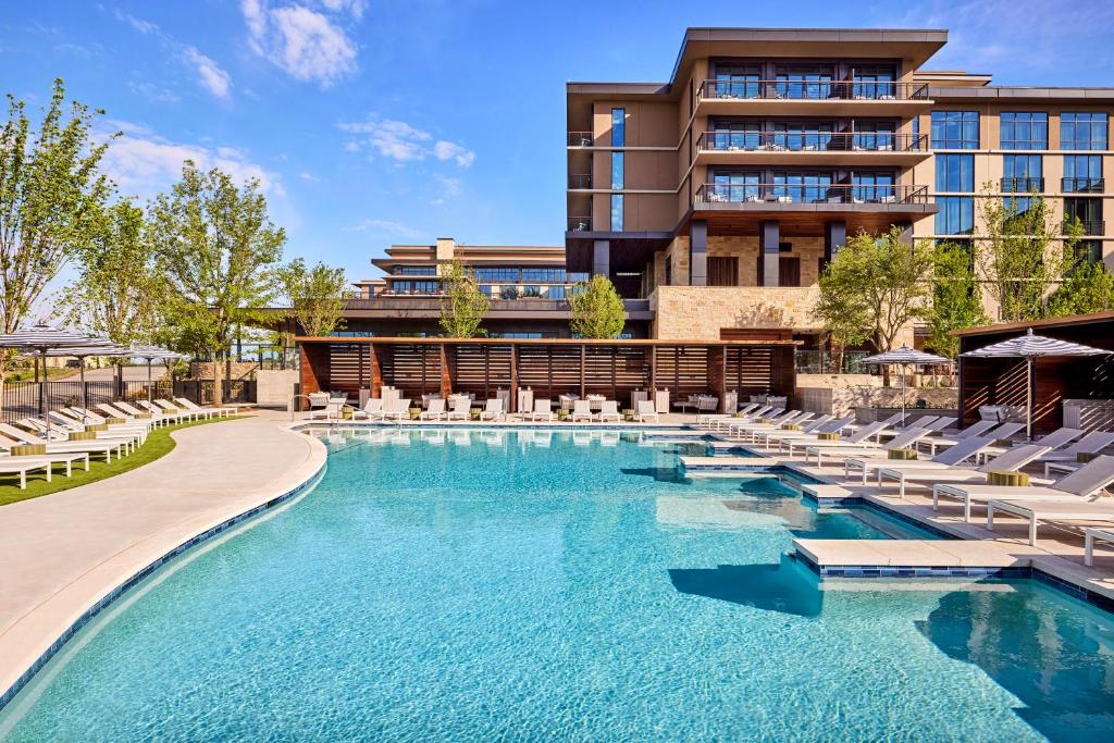 einen Pool mit Liegestühlen und ein Hotel in der Unterkunft Omni PGA Resort Frisco-Dallas in Frisco