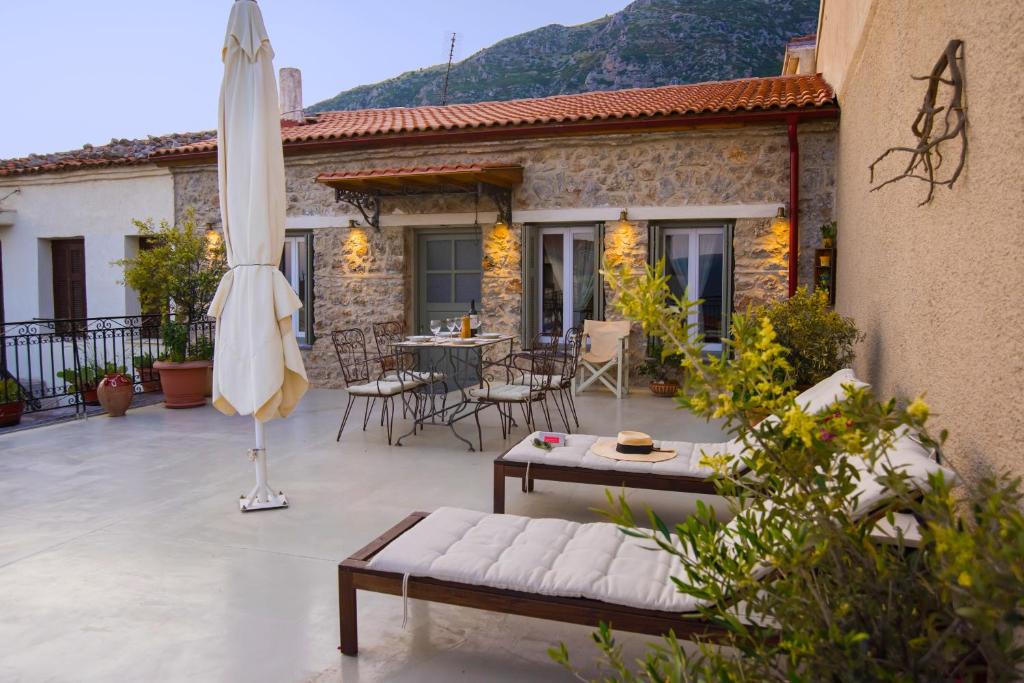 a patio with an umbrella and a table and chairs at Guesthouse Simou with view 3 bedrooms in Arachova