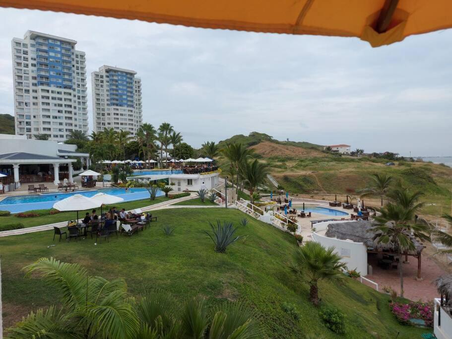a view of a resort with a pool and buildings at Moderno Dpto al pie del mar piscina/jacuzzi in Playas