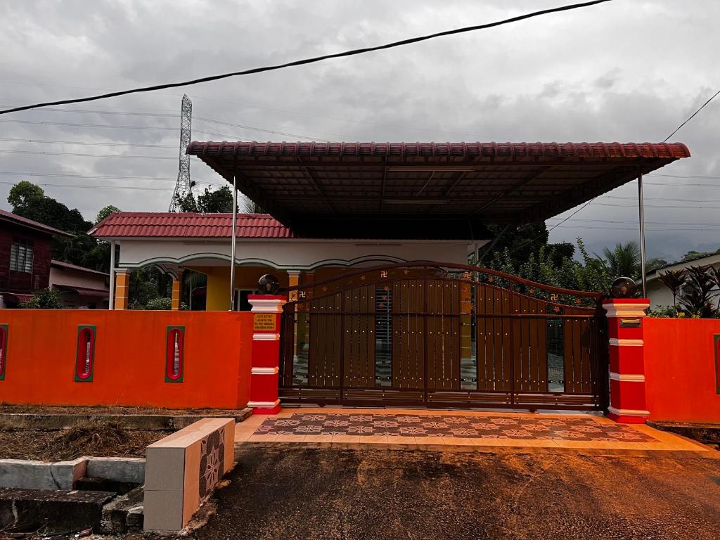 une porte menant à une maison dotée d'une clôture orange dans l'établissement VINDRA HOMESTAY, à Bidur