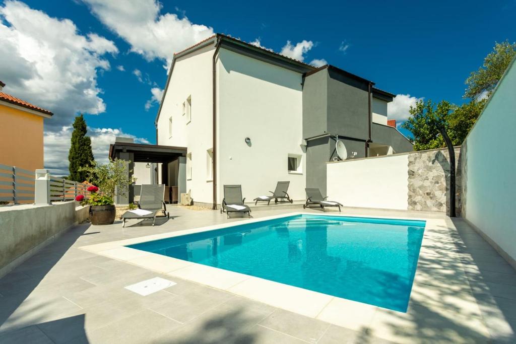 a swimming pool in the backyard of a house at Holiday home Krk -with private pool in Soline