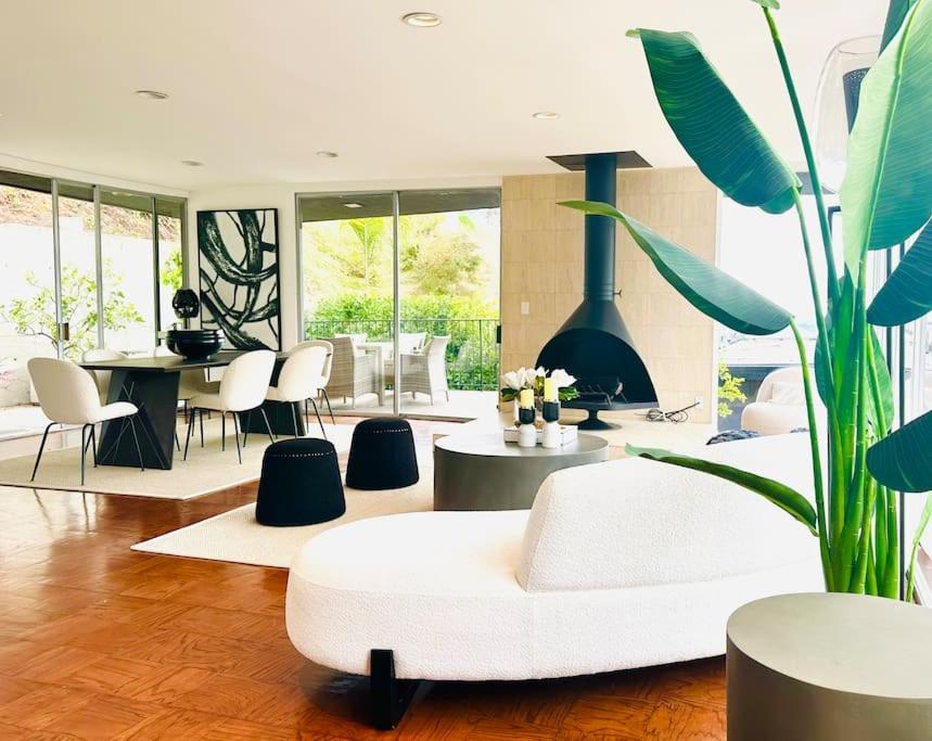 sala de estar con sofá blanco y chimenea en Urban Oasis: Stylish Mid-Century Home in Weho en Los Ángeles