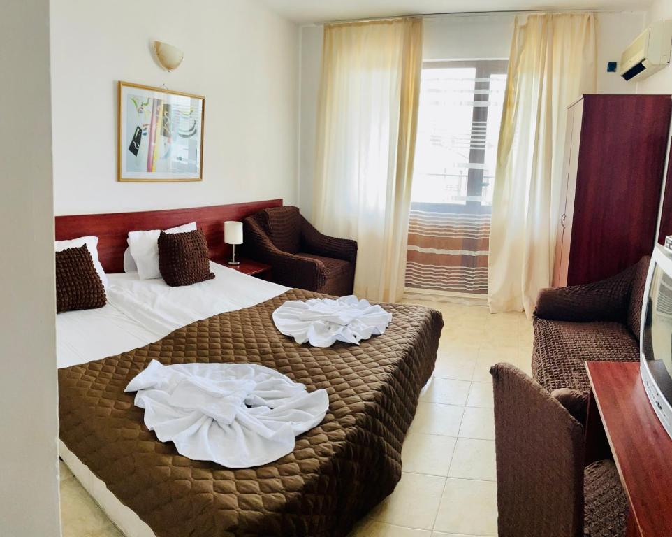 a hotel room with a bed with towels on it at Family Hotel YALTA Свети Влас in Sveti Vlas