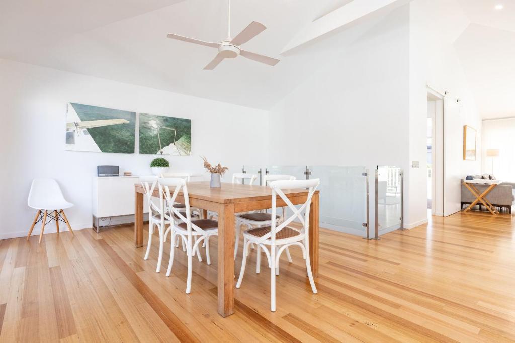 a kitchen and dining room with a table and chairs at Banksia in Blueys Beach