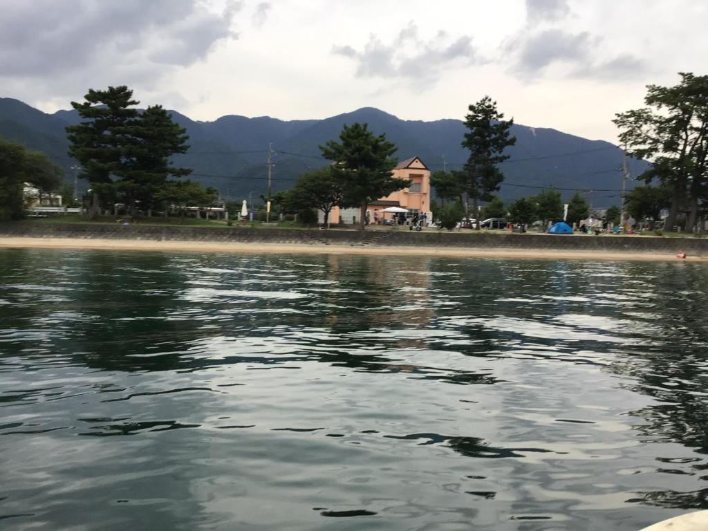 uma vista para a praia a partir da água em ペンションレークサイド em Otsu