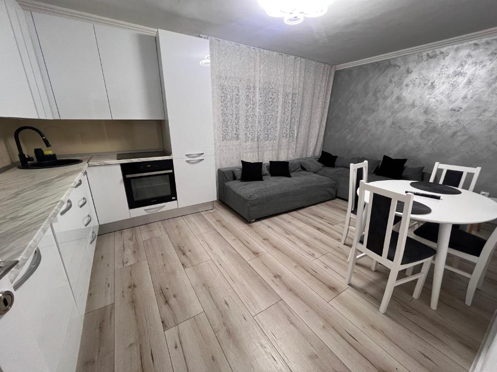 een keuken en een woonkamer met een tafel en een bank bij EBI Apartment in Cluj-Napoca