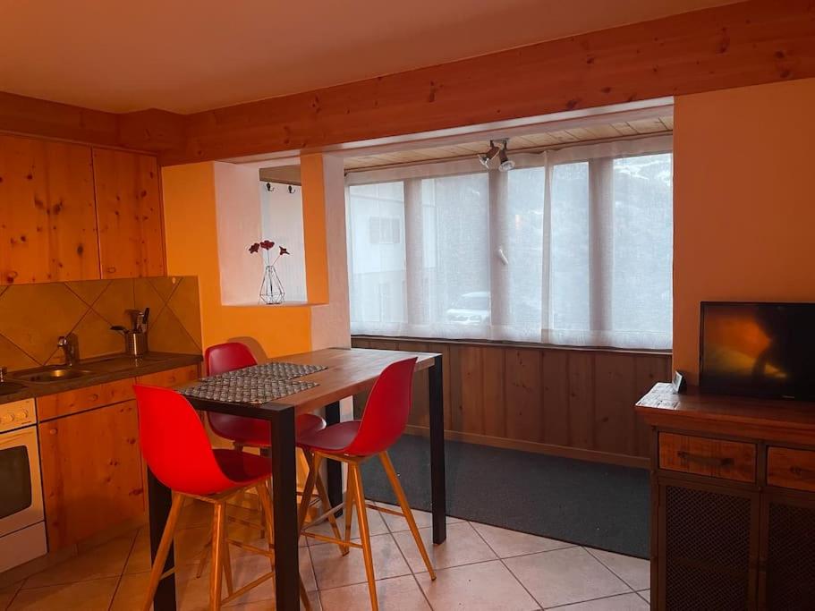 una cucina con tavolo, sedie e TV di Petit studio à Lourtier a Lourtier