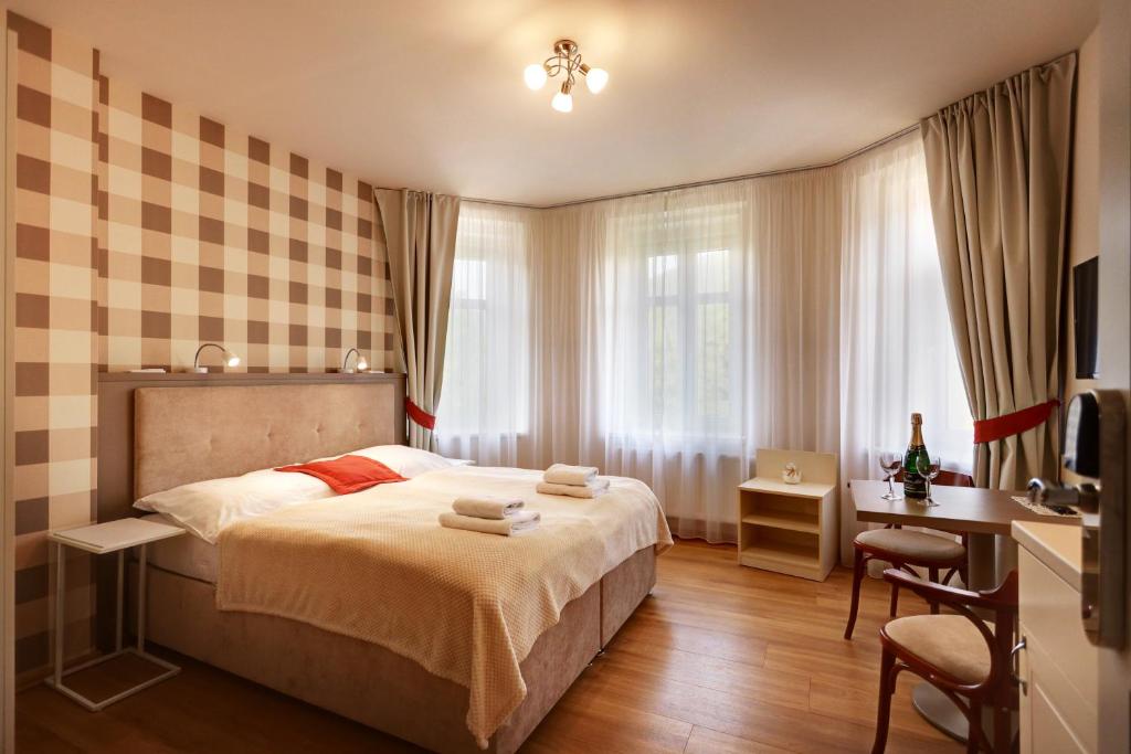 um quarto com uma cama, uma secretária e uma janela em APARTMÁNY ADAM em Jáchymov