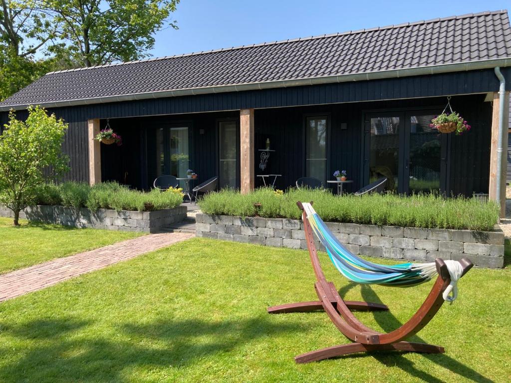a chair sitting in the grass in front of a house at De Burcht-Drenthe in Bunne