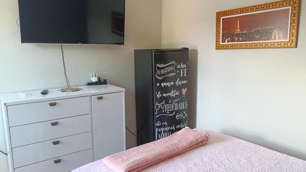 Zimmer mit einem schwarzen Kühlschrank und einer Kommode in der Unterkunft Apartamento El Shadai 02 in Porto Seguro