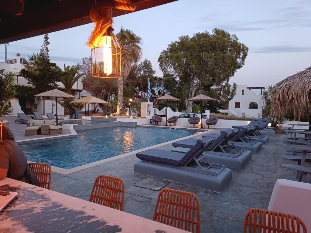 a resort pool with lounge chairs and a light fixture at Naxos Summerland resort in Kastraki