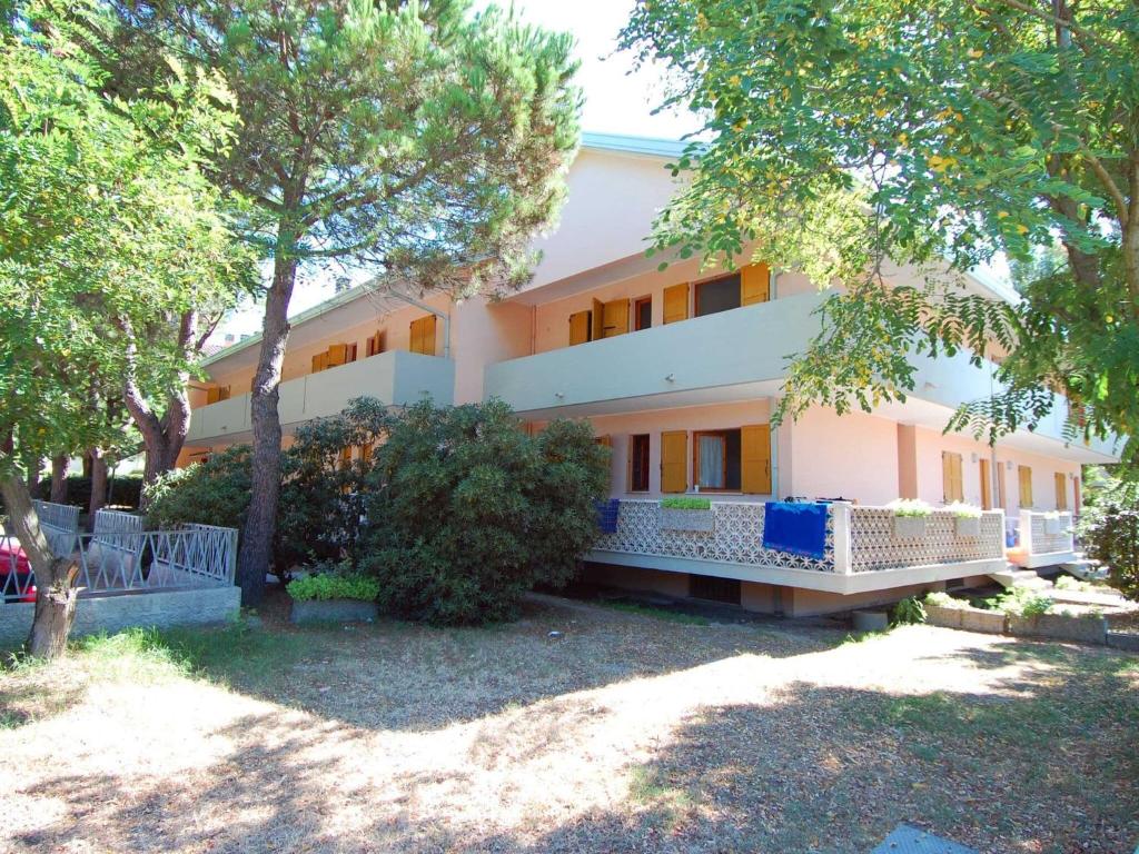 een groot wit gebouw met bomen ervoor bij Sun drenched seaside holiday home close to Venice in Rosolina Mare
