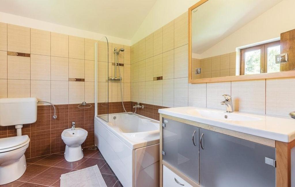a bathroom with a toilet and a sink and a tub and a toilet istg at Villa Family in Medulin