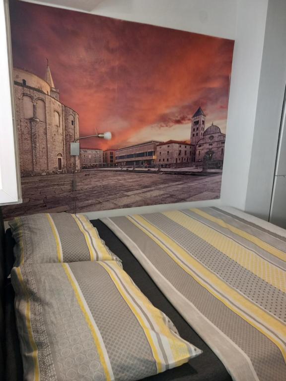 een bed in een kamer met een schilderij aan de muur bij Cvita & Maja in Zadar