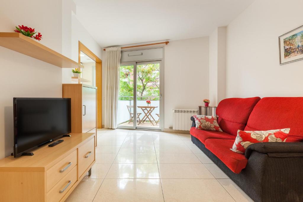 sala de estar con sofá rojo y TV en Navas 2, en Barcelona