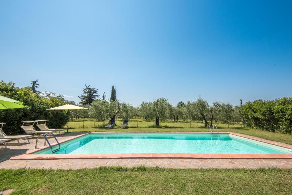 - une piscine avec une table et deux chaises dans l'établissement Villa Il Poggio di San Gimignano, à Borgatello