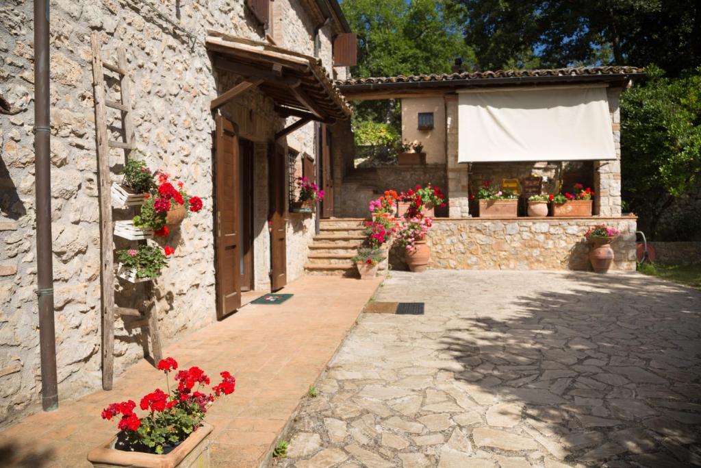 een stenen gebouw met bloemen aan de zijkant bij Casa tra le Querce in Avigliano
