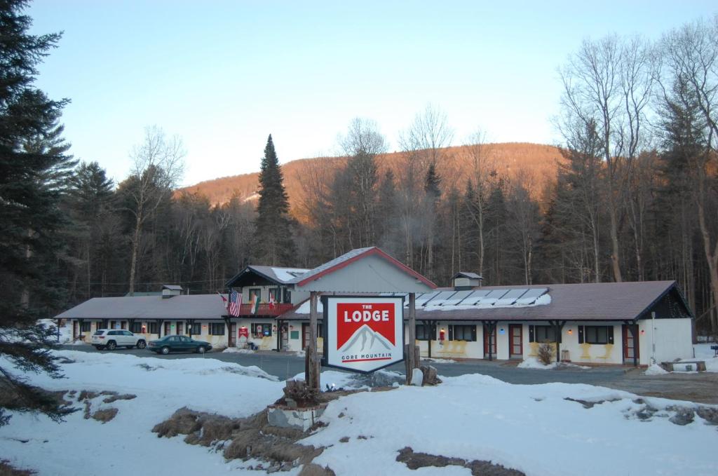 un hotel con un cartel en la nieve en Gore Mountain Lodge, en North Creek