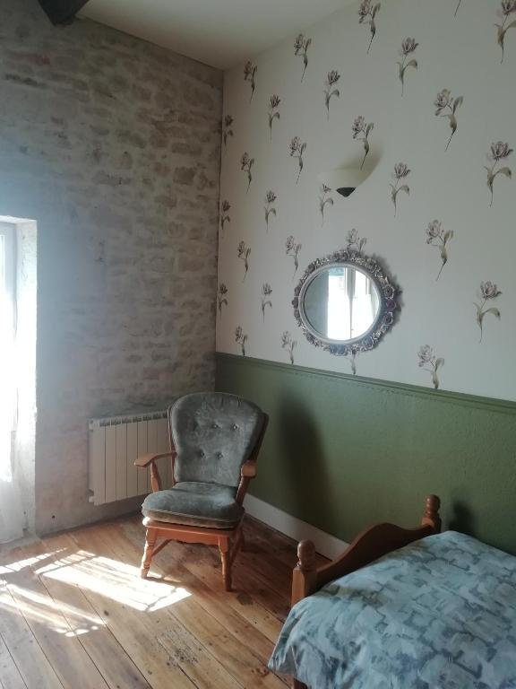 a bedroom with a bed and a chair and a mirror at Thunder Roadhouse in La Mothe-Saint-Héray