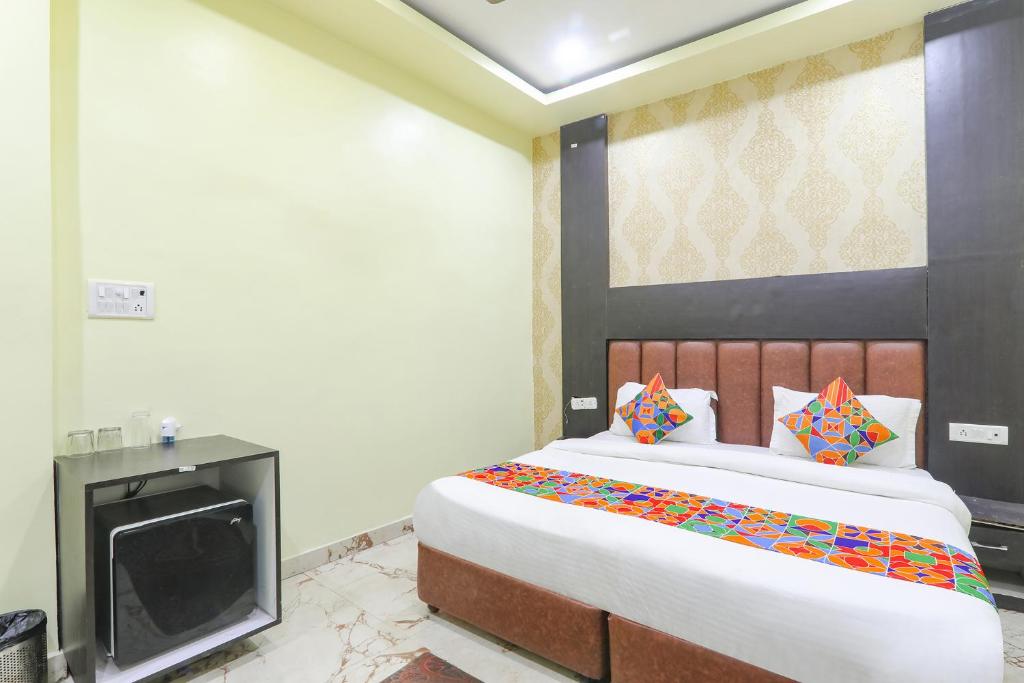 a bedroom with a large bed and a tv at FabExpress GS Residency in Varanasi