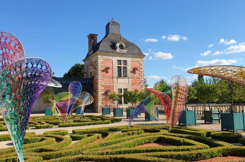 a garden with colorful butterflies in front of a building at Thunder Roadhouse in La Mothe-Saint-Héray