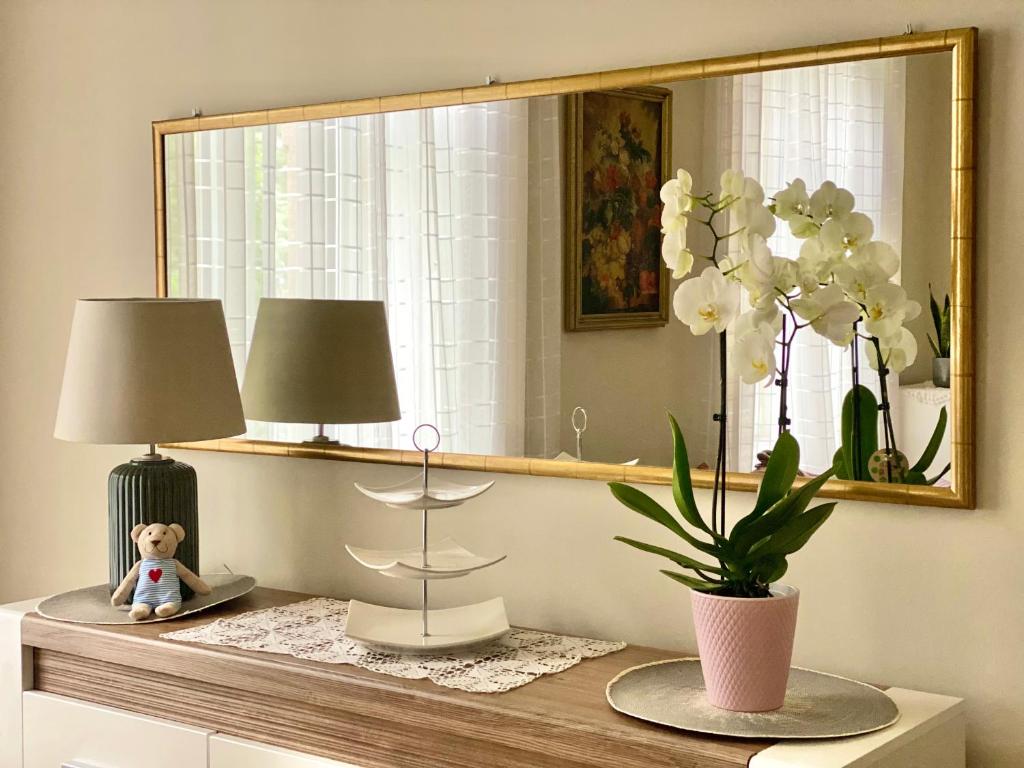 una mesa con dos lámparas y un jarrón de flores blancas en Teresa Apartment, en Budapest