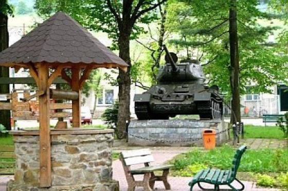a tank in a park with a bench and a gazebo at Całoroczny Domek Dwukondygnacyjny in Baligród