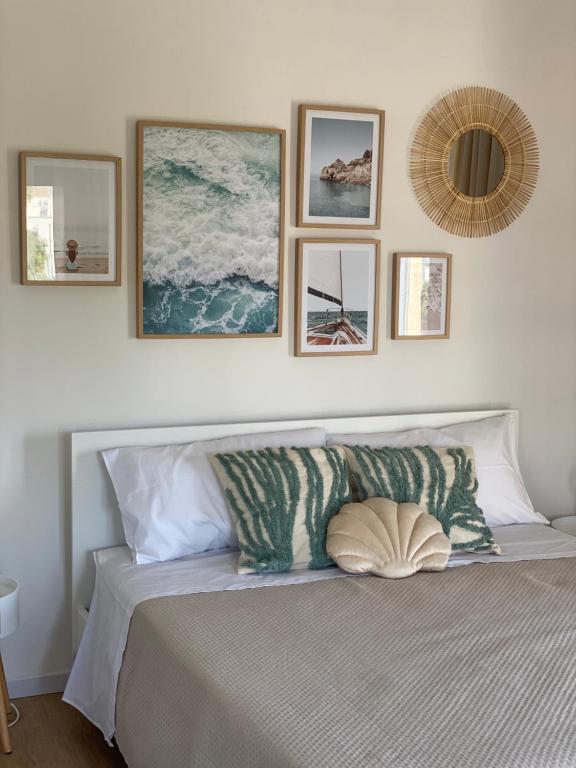 a bedroom with a bed with four pictures on the wall at Chez Lina - Appartamento Marina in Trapani
