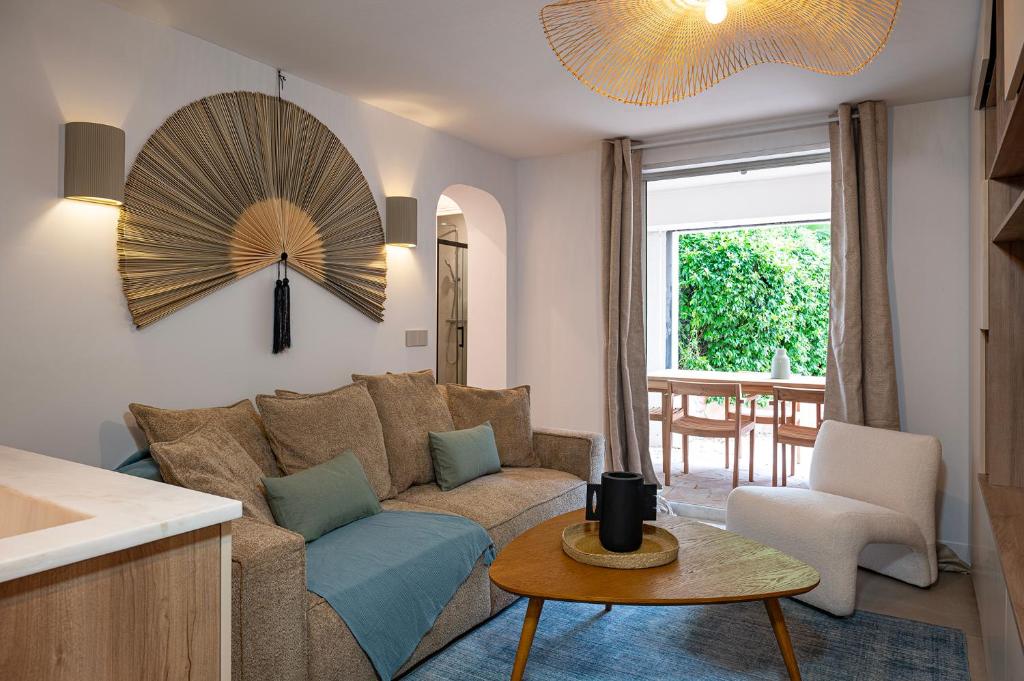 een woonkamer met een bank en een tafel bij Superbe 3 pièces dans Saint Tropez avec piscine et terrasse in Saint-Tropez