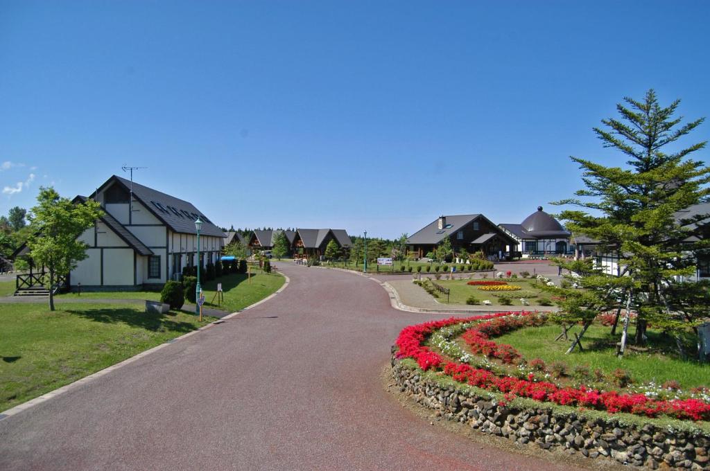 uma estrada sinuosa num bairro residencial com flores em Awone Shirakami Juniko em Fukaura