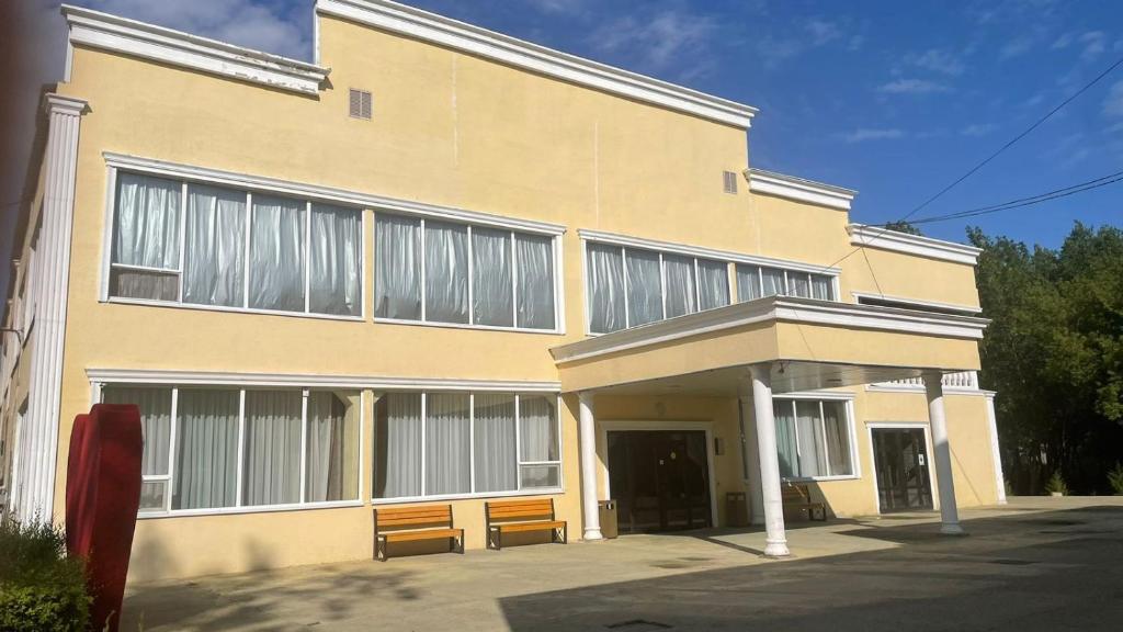 a building with two benches in front of it at PARK HOTEL Uralsk in Uralsk