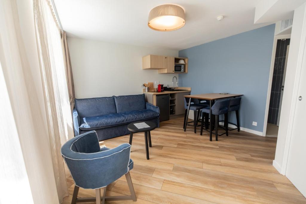 a living room with a couch and a table at Hôtel de la Baie in Crozon