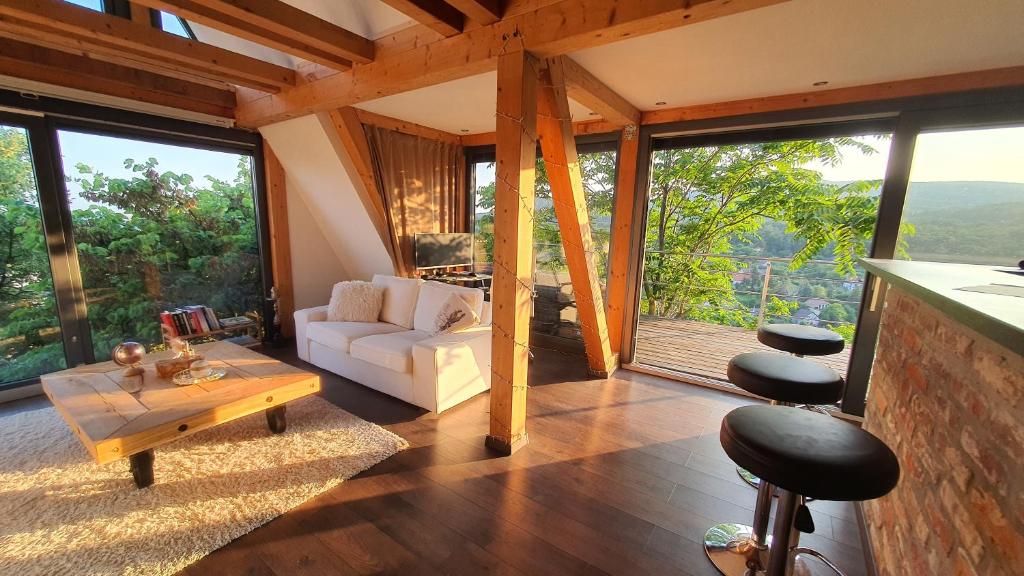 sala de estar con sofá y mesa en Modern cottage, views and a jacuzzi, en Pécs