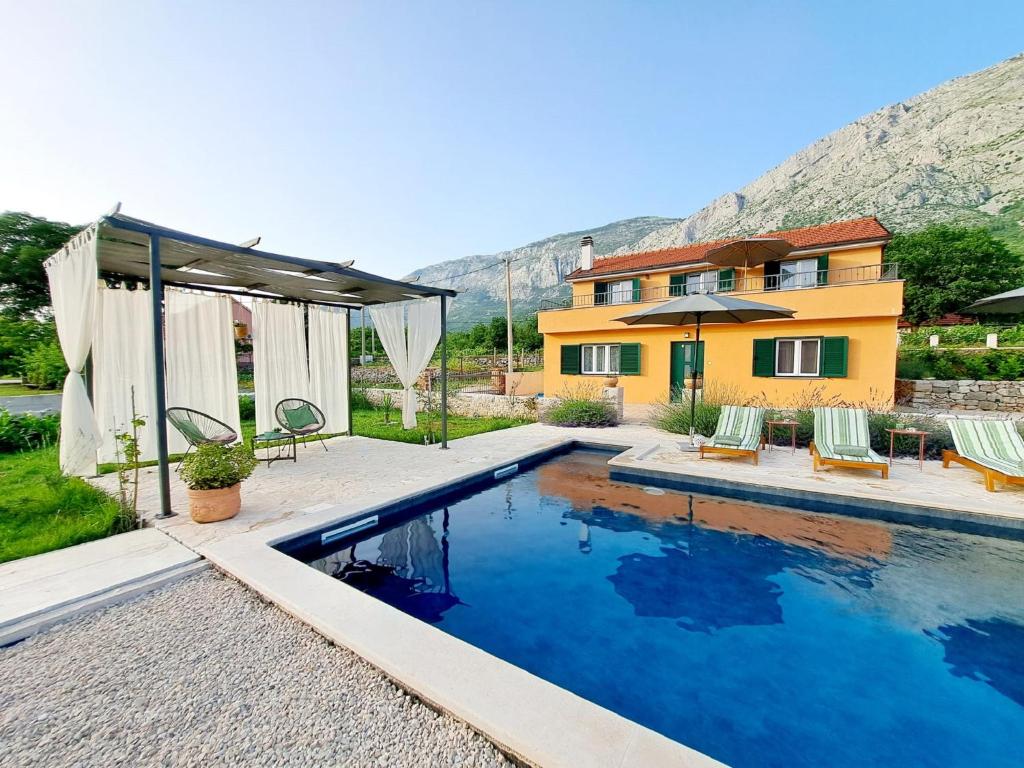 a house with a swimming pool in front of a house at Villa Vinka in Kozica