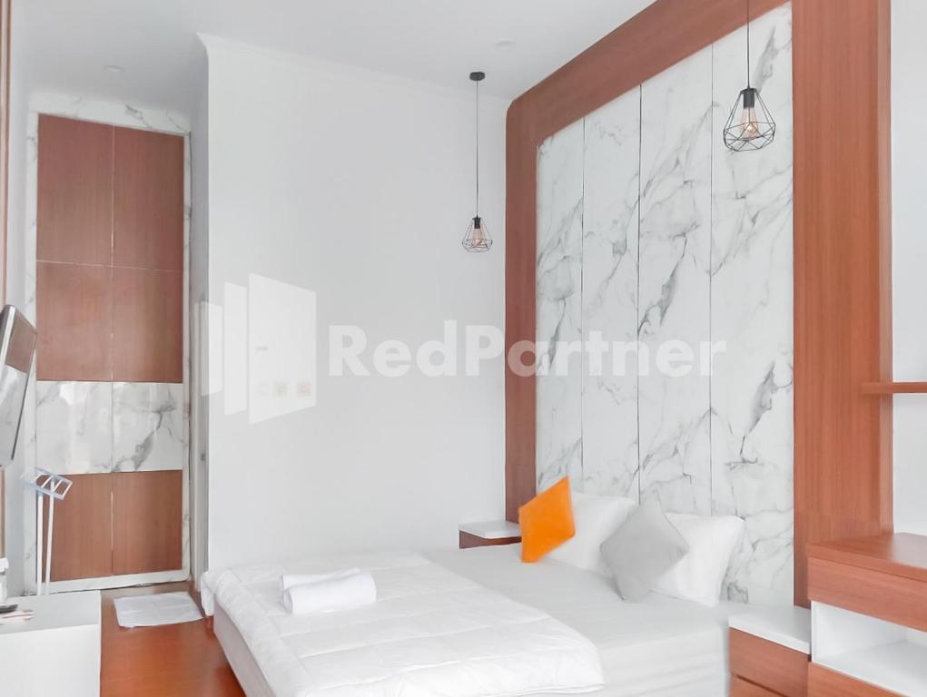 a room with a bed and a wall at Khayrizsan Guest House Mitra RedDoorz in Cibeureum
