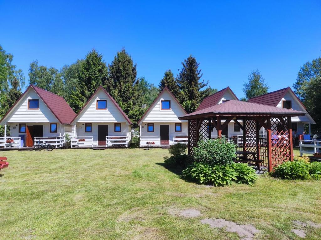 a row of cottages with a yard at Domki Letniskowe Bryza in Jarosławiec
